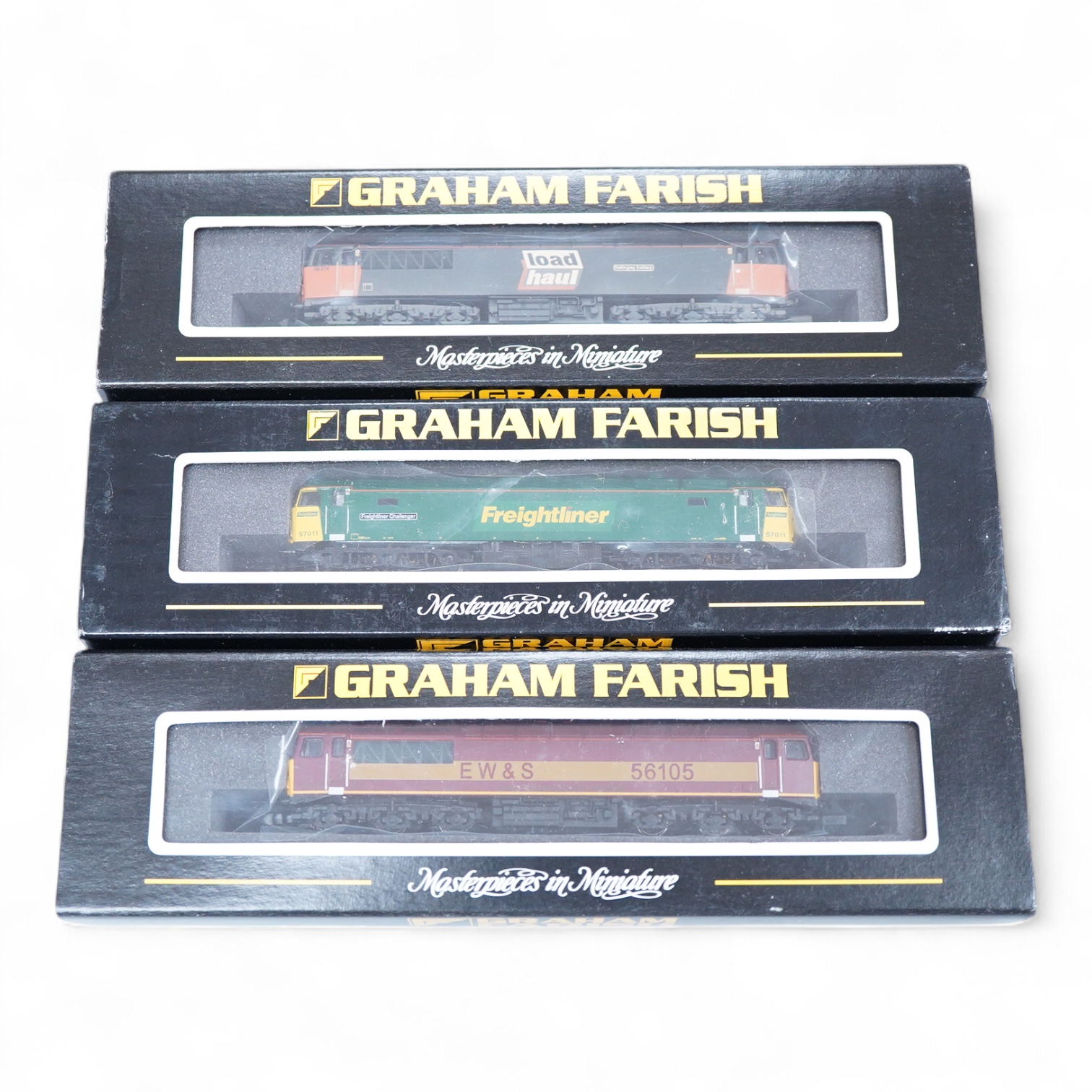 Three boxed Graham Farish N gauge railway diesel locomotives; an EWS class 56, 56105 (371300), a Load Haul class 56, Kellingley Colliery 56 074 (371301), and a Freightliner class 57, Freightliner Challenger 57011, (37122